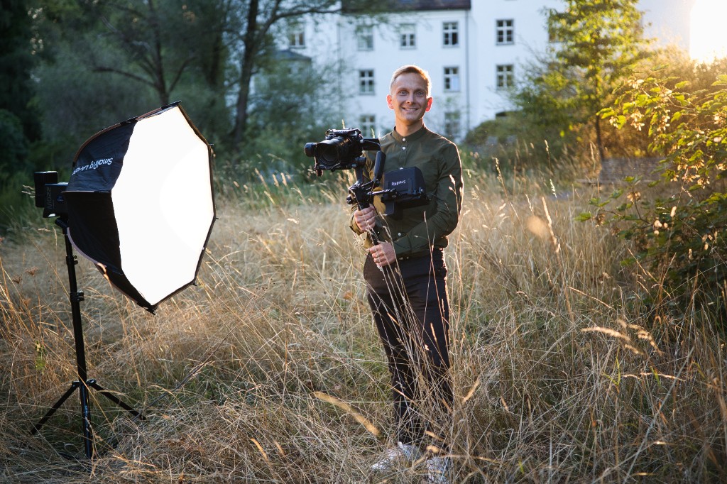 Jeremias Forell mit Gimbal und Softbox vor dem weissen Schloss