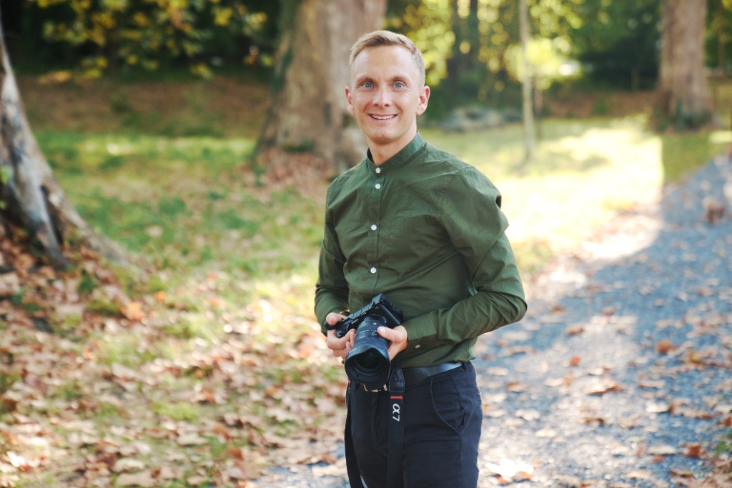 Jeremias Forell lächelt in die Kamera und hält seine Sony Alpha